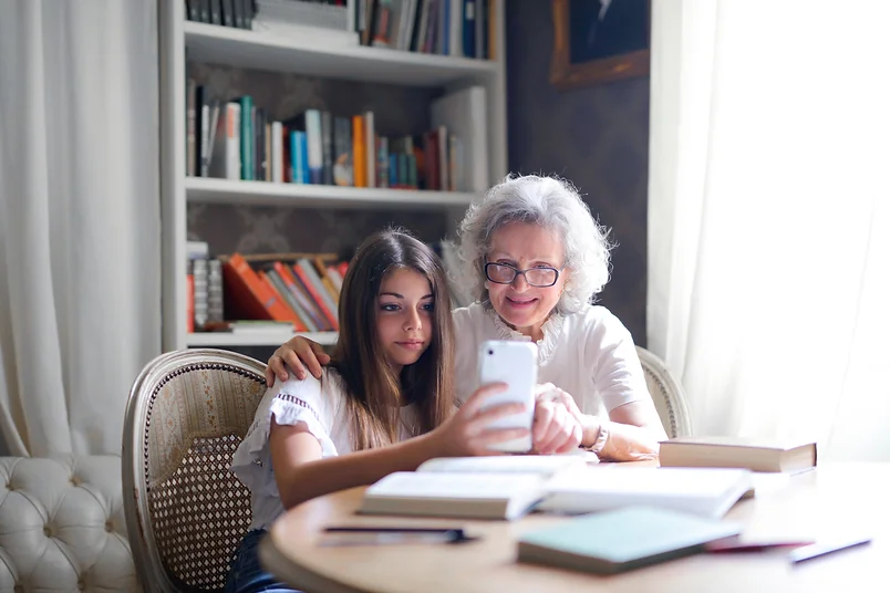 A grandmother and granddaughter looking at a cell phone